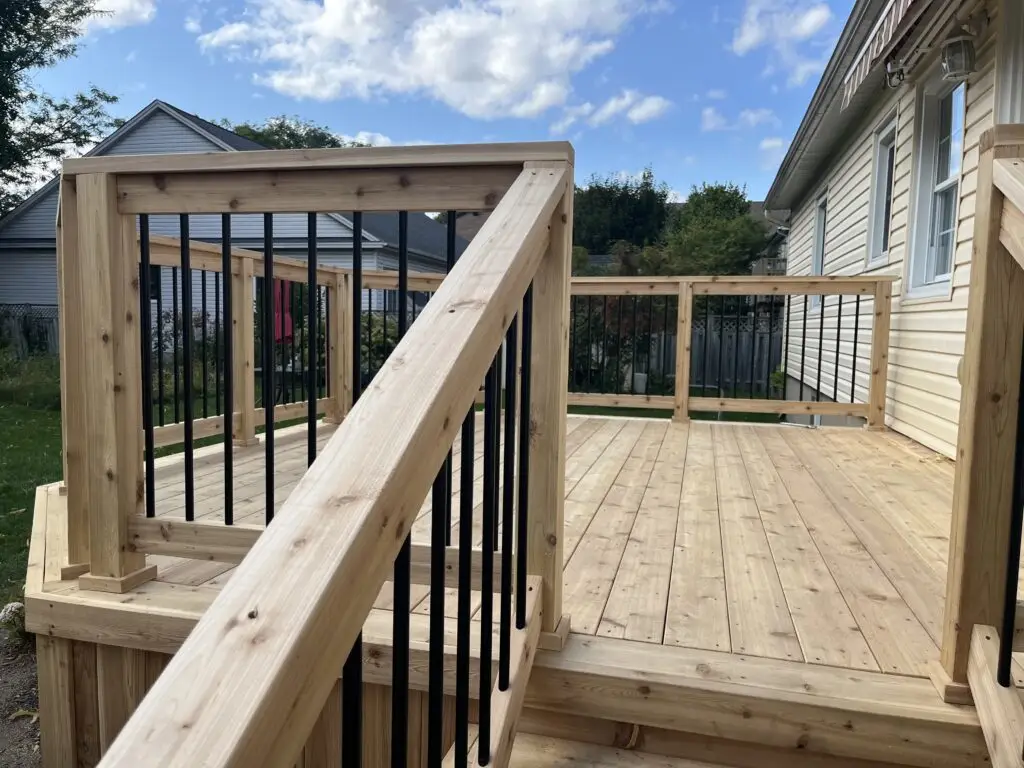 A cedar deck in Barrhaven. The deck has a cedar railing with black aluminum ballusters